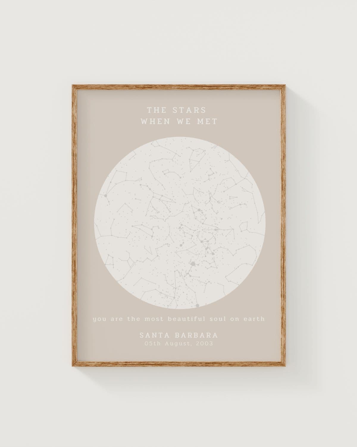 Personalisierte Sternenkarte 'The Stars When We Met' im Naturholzrahmen an einer hellen Wand